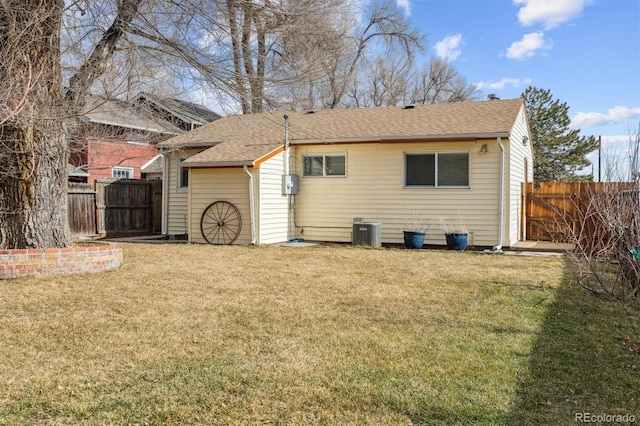 back of property featuring a yard and central AC