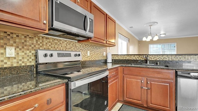 kitchen with stainless steel appliances, ornamental molding, sink, and dark stone counters