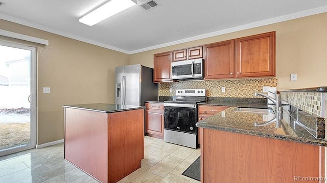 kitchen featuring sink, crown molding, appliances with stainless steel finishes, backsplash, and a kitchen island