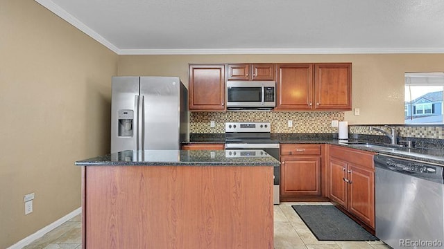 kitchen with sink, dark stone countertops, stainless steel appliances, a center island, and tasteful backsplash