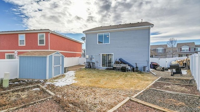 back of house with a storage unit