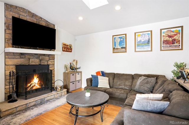 living room with a skylight, a fireplace, hardwood / wood-style floors, and recessed lighting