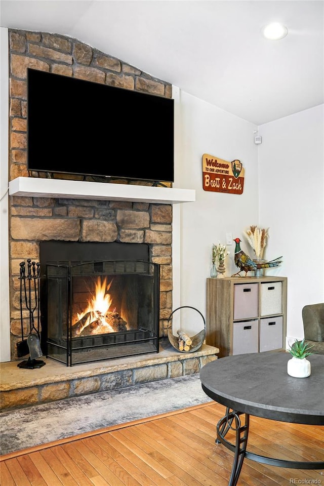 interior space with a stone fireplace and hardwood / wood-style floors