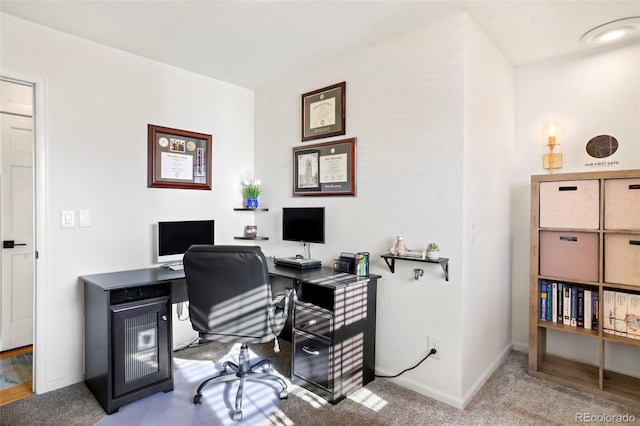 office space featuring light carpet and baseboards