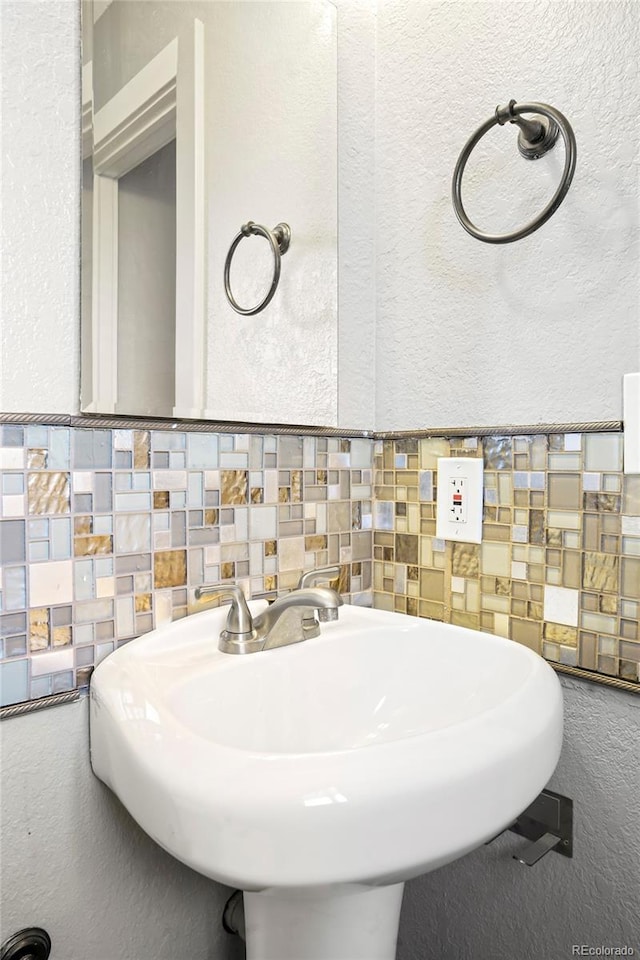 bathroom with tile walls, a sink, and a textured wall