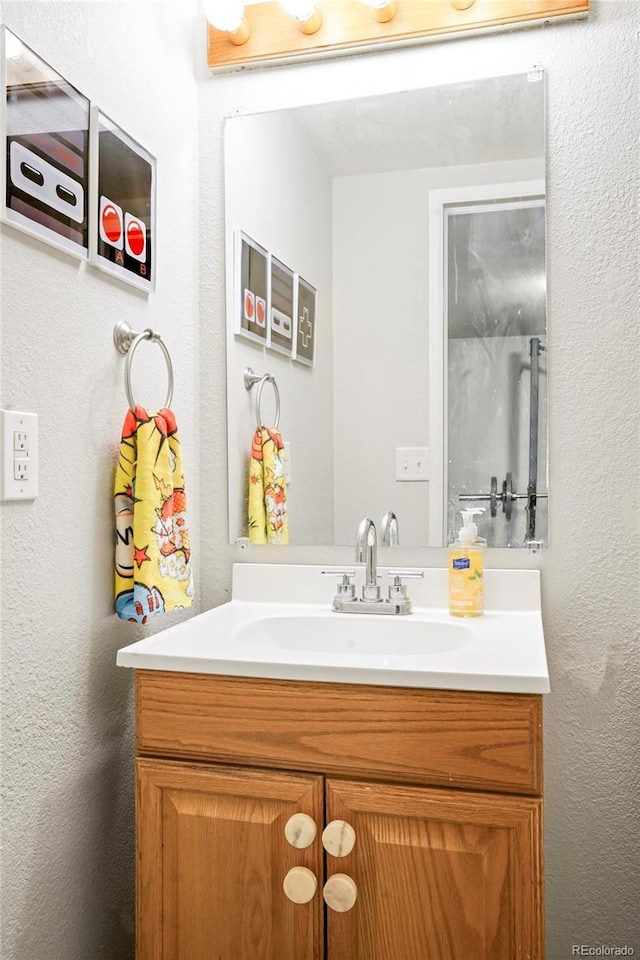 bathroom featuring a textured wall and vanity