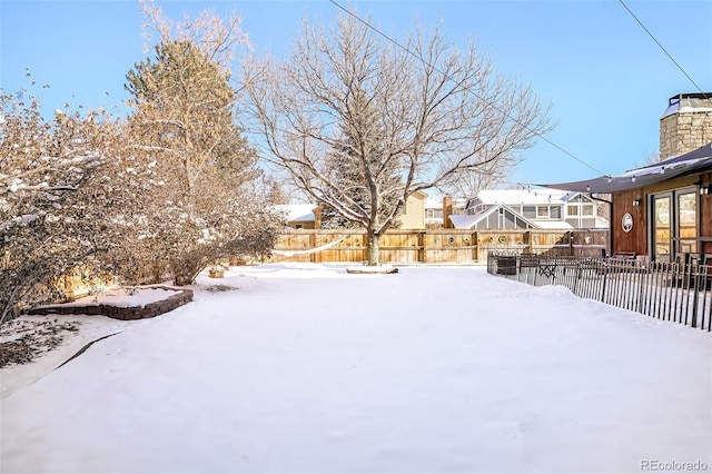 yard layered in snow featuring a fenced backyard