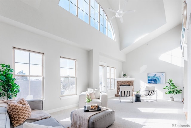 living room featuring light carpet, a towering ceiling, and ceiling fan