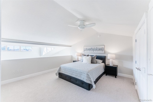 bedroom with vaulted ceiling, light colored carpet, and ceiling fan