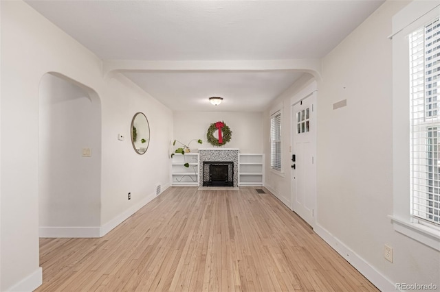 unfurnished living room with a fireplace and light hardwood / wood-style floors