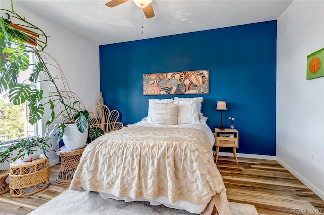 bedroom featuring wood finished floors, baseboards, and ceiling fan