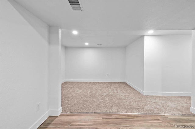 finished basement with recessed lighting, visible vents, carpet flooring, wood finished floors, and baseboards