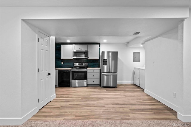 kitchen with light wood-style flooring, independent washer and dryer, stainless steel appliances, light countertops, and backsplash