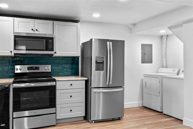 kitchen with washing machine and dryer, appliances with stainless steel finishes, white cabinets, and light countertops