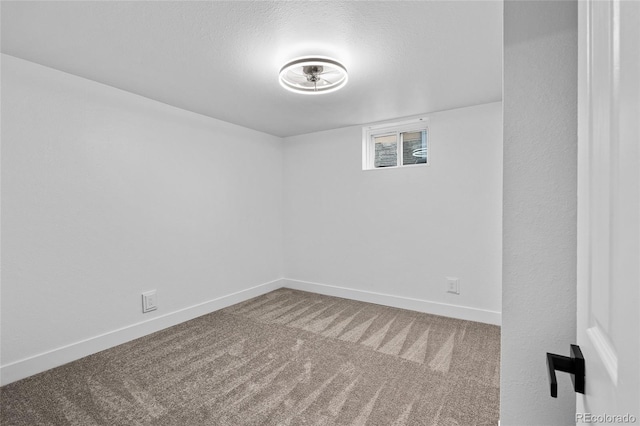 carpeted spare room with baseboards and a textured ceiling