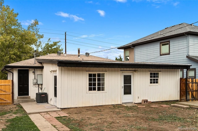 back of house featuring a shingled roof and fence