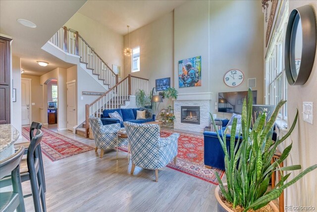2347 S Loveland St, Lakewood, CO 80228 - living room with light wood-type flooring, stairs, a towering ceiling, and a fireplace