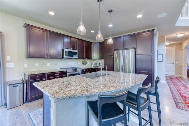 2347 S Loveland St, Lakewood, CO 80228 - kitchen featuring appliances with stainless steel finishes, a sink, light wood-style floors, decorative light fixtures, and recessed lighting
