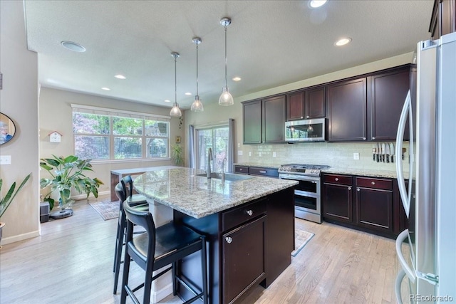 2347 S Loveland St, Lakewood, CO 80228 - kitchen featuring appliances with stainless steel finishes, a sink, light wood-style floors, a kitchen island, and recessed lighting