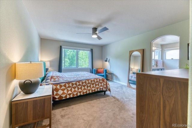 2347 S Loveland St, Lakewood, CO 80228 - carpeted bedroom with arched walkways, multiple windows, a ceiling fan, and baseboards