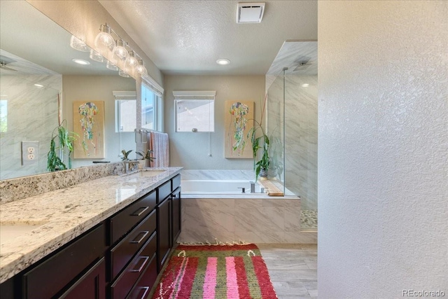 2347 S Loveland St, Lakewood, CO 80228 - bathroom with a bath, a shower stall, double vanity, a textured ceiling, and a textured wall