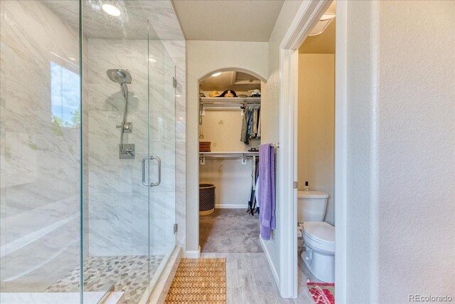 2347 S Loveland St, Lakewood, CO 80228 - full bath featuring a stall shower, a spacious closet, toilet, and wood finished floors