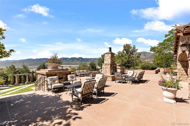 2347 S Loveland St, Lakewood, CO 80228 - view of patio with a mountain view and an outdoor living space with a fireplace