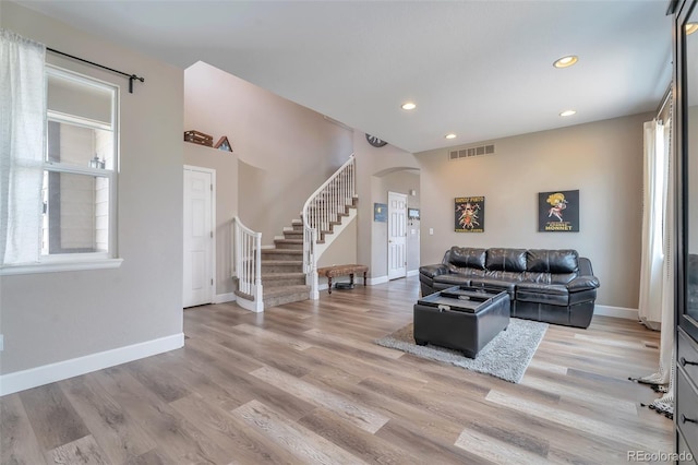 10695 Wynspire Rd, Highlands Ranch, CO 80130 - living room with arched walkways, stairs, recessed lighting, baseboards, and light wood finished floors