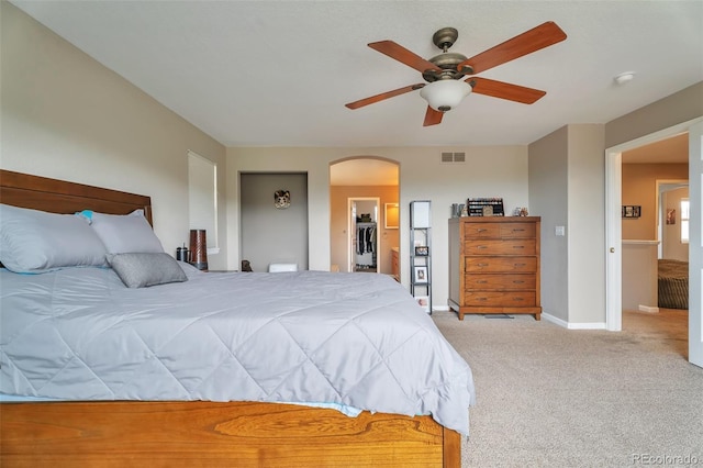 10695 Wynspire Rd, Highlands Ranch, CO 80130 - bedroom with arched walkways, carpet flooring, baseboards, a ceiling fan, and a walk in closet
