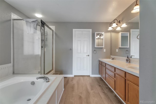 10695 Wynspire Rd, Highlands Ranch, CO 80130 - bathroom with double vanity, a garden tub, a stall shower, and wood finished floors