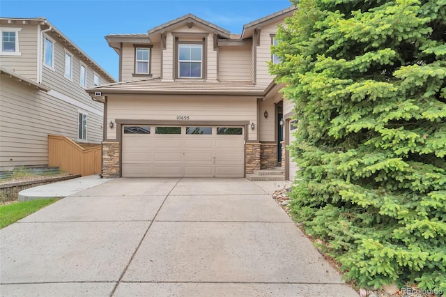 10695 Wynspire Rd, Highlands Ranch, CO 80130 - view of front of property with an attached garage, concrete driveway, stone siding, and a tile roof