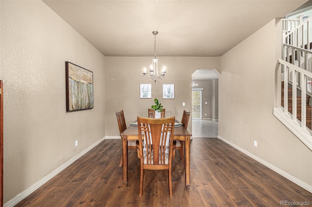 dining area with dark hardwood / wood-style floors and a chandelier