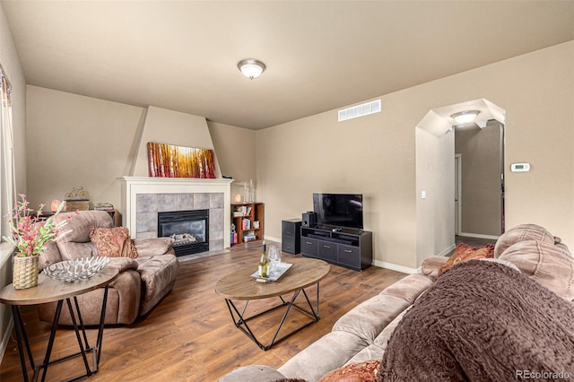 living room with hardwood / wood-style floors and a tiled fireplace