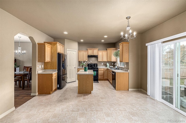 kitchen featuring black appliances, a chandelier, sink, a kitchen island, and decorative light fixtures