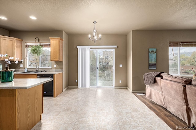 kitchen with a wealth of natural light, an inviting chandelier, decorative light fixtures, and black dishwasher