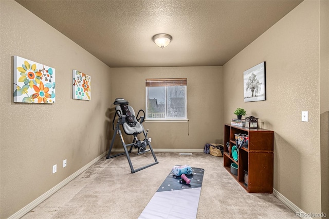 workout area featuring carpet floors and a textured ceiling