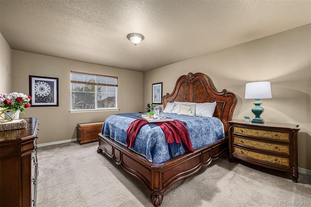 bedroom with a textured ceiling and light carpet