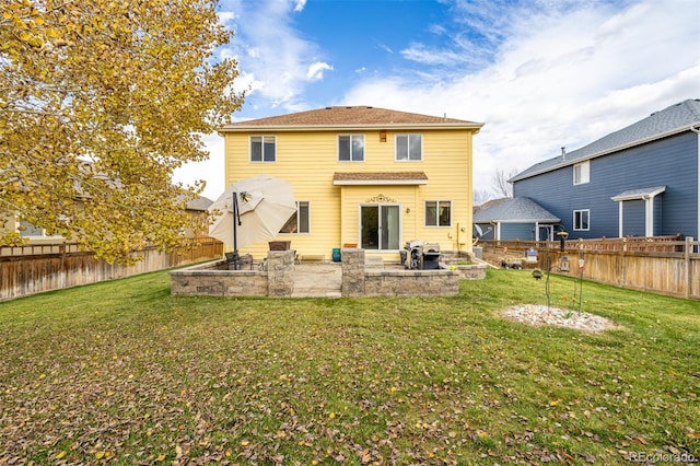 back of property with a yard and a patio