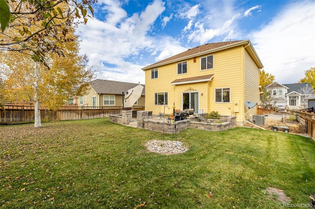 back of property with central AC unit, a patio, and a yard