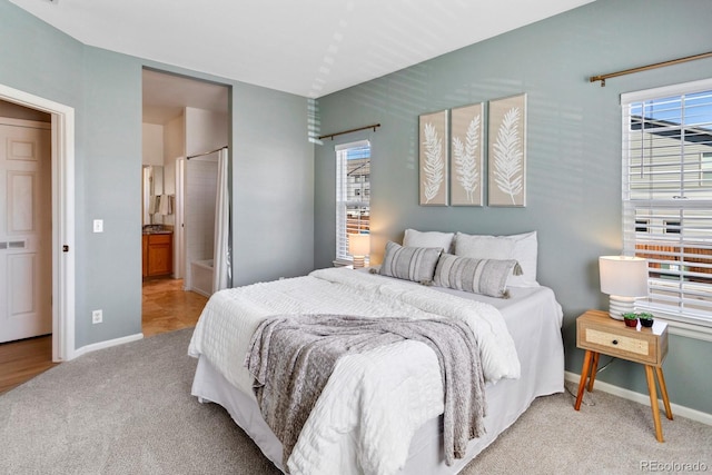 bedroom featuring baseboards, multiple windows, and light colored carpet