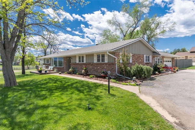 10220 W Montgomery Ave, Littleton, CO 80127 - single story home with brick siding, board and batten siding, a garage, a front yard, and driveway
