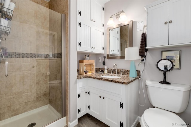 10220 W Montgomery Ave, Littleton, CO 80127 - bathroom with toilet, a shower stall, vanity, baseboards, and wood finished floors