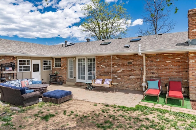 10220 W Montgomery Ave, Littleton, CO 80127 - rear view of property featuring an outdoor living space, brick siding, a patio, and a shingled roof