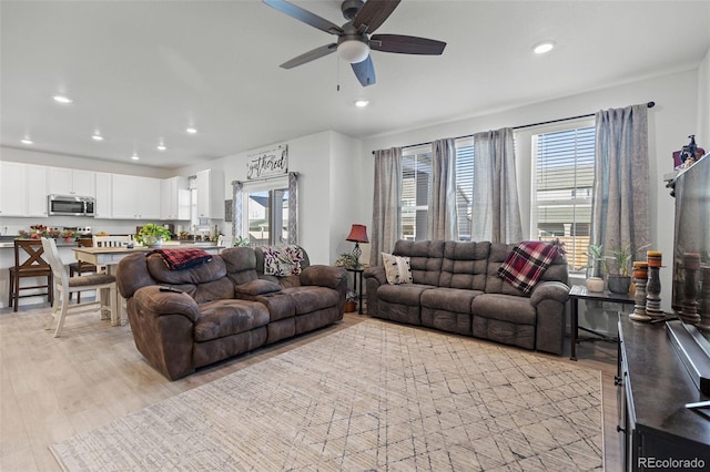 living room featuring ceiling fan and light hardwood / wood-style flooring