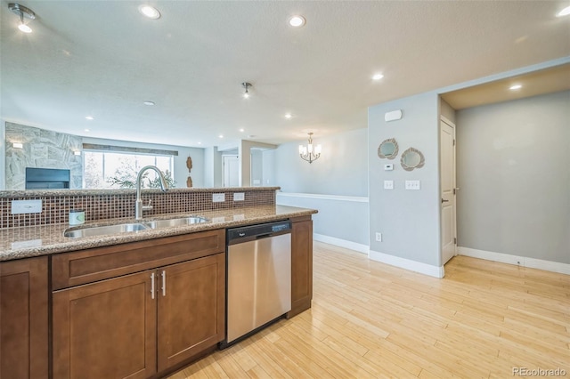 2539 N York St, Denver, CO 80205 - kitchen with a sink, stainless steel dishwasher, backsplash, light stone counters, and a chandelier