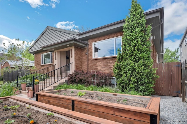 2539 N York St, Denver, CO 80205 - view of front of property with a vegetable garden, fence, and brick siding