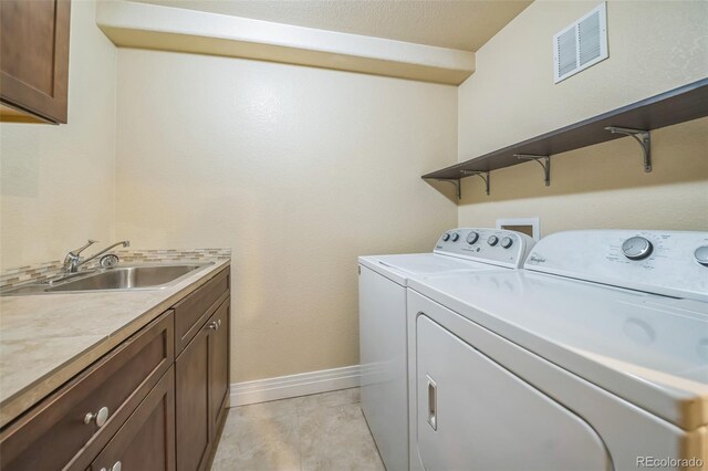 2539 N York St, Denver, CO 80205 - clothes washing area with independent washer and dryer, baseboards, cabinet space, and light tile patterned flooring
