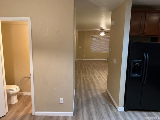 corridor featuring baseboards and light wood-style floors