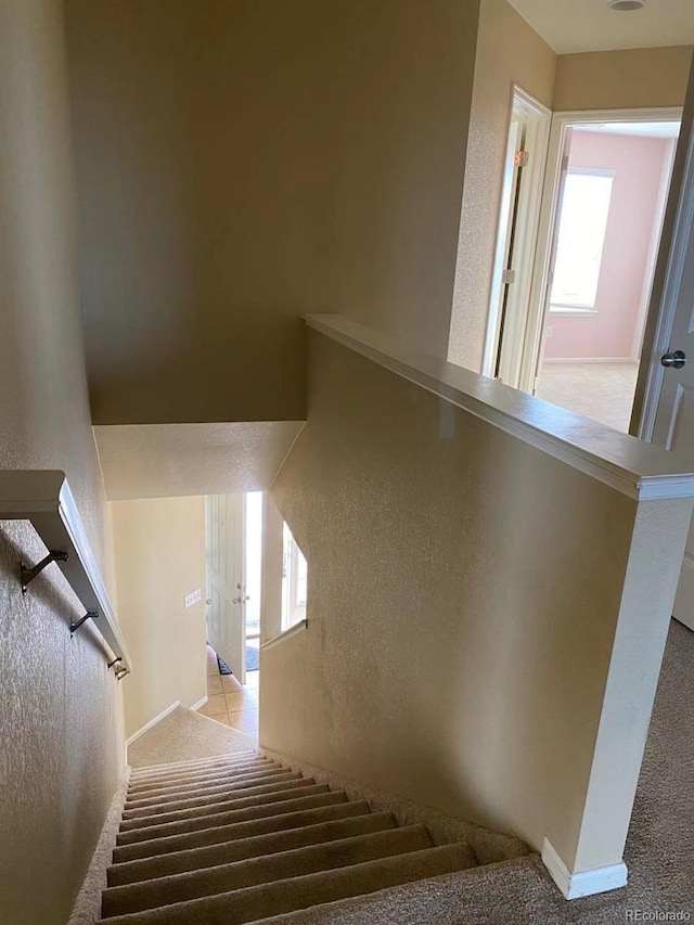 staircase featuring a textured wall