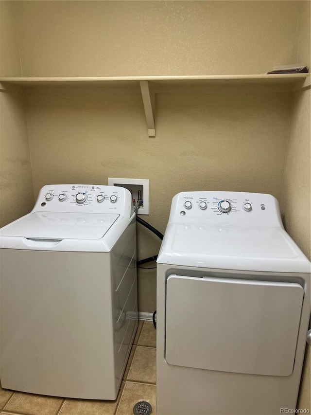 washroom with light tile patterned flooring, laundry area, and washer and clothes dryer